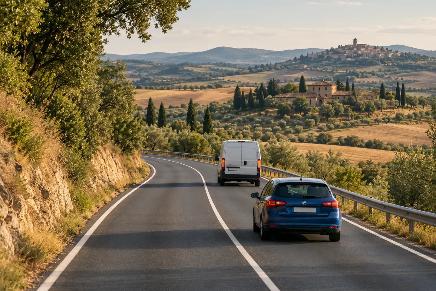 A car follows a van beside a solid centre line on a Spanish road